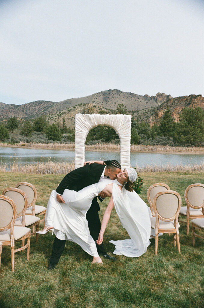 Couple does a dip in the aisle of the ceremony space at Ranch at the Canyons
