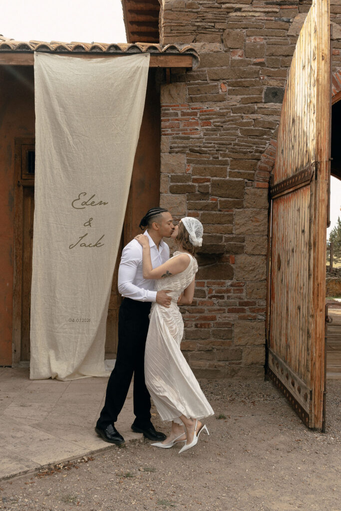 Couple kisses near The Tuscan Stables at Ranch at the Canyons