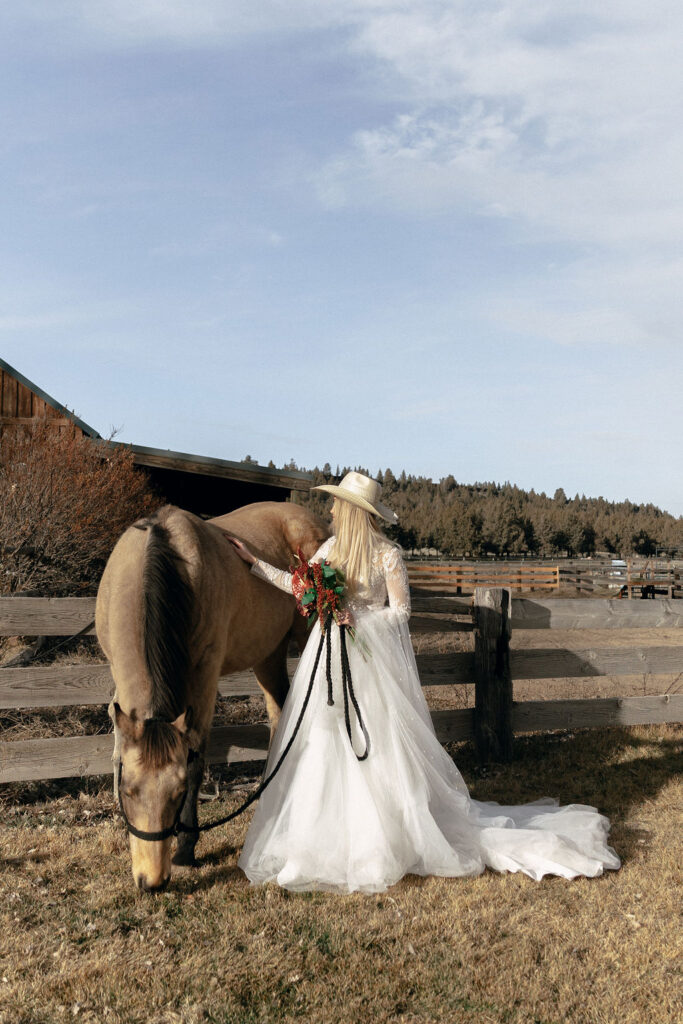 Bride stands with a horse at Long Hollow Ranch