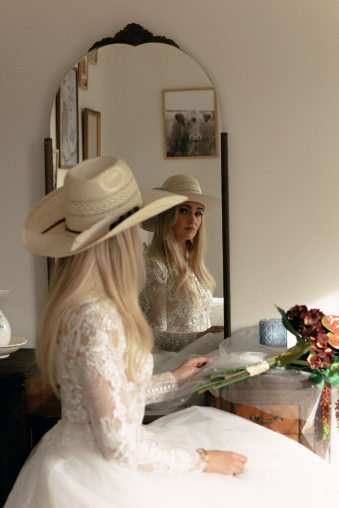 Bride looks in a mirror in the getting ready space at Long Hollow Ranch